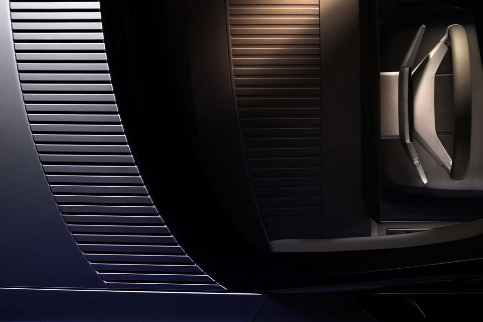 Close-up of the Jaguar Type 00 concept car interior showing sculpted ribbed door trim panels and a seat headrest with ambient lighting