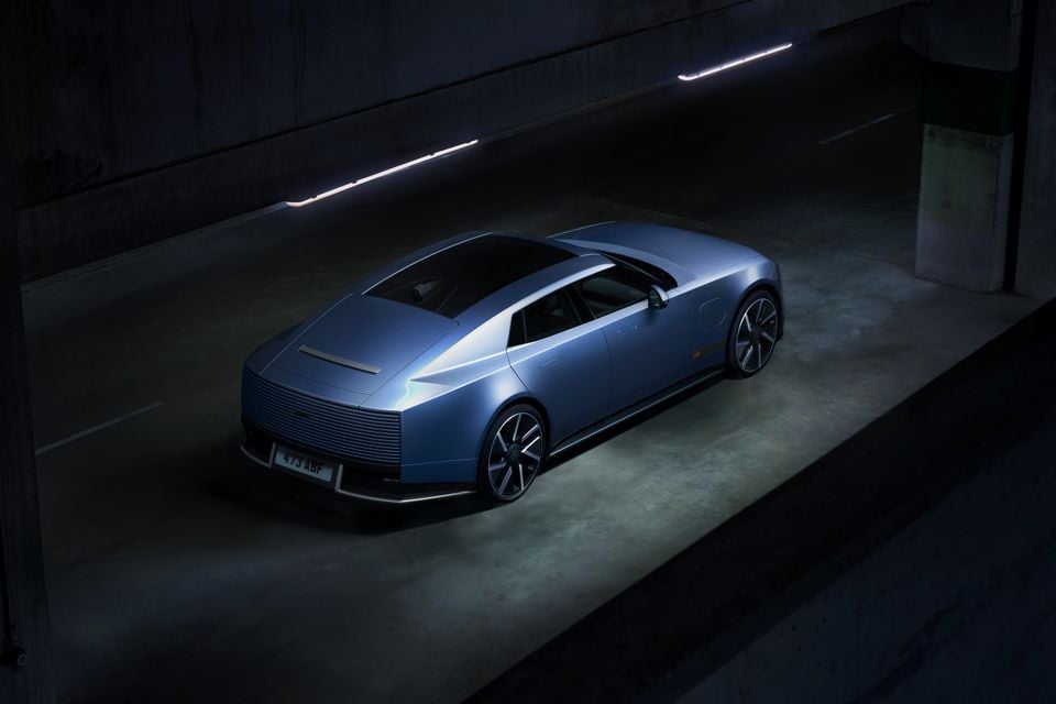 A blue Jaguar Type-00 concept car parked in a dark underground structure, viewed from above and the rear.