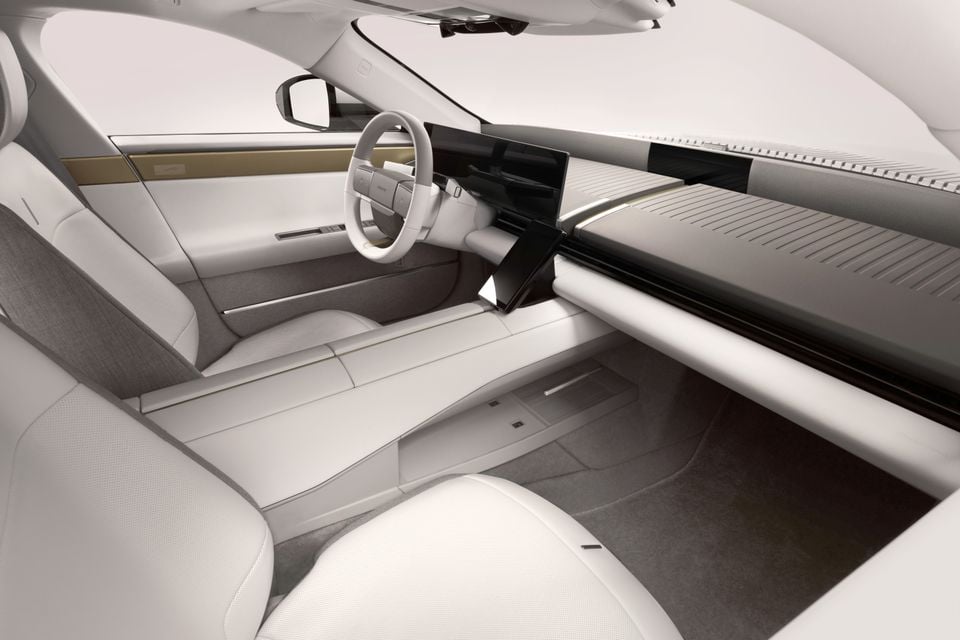 A view of the minimalist white and grey concept car interior showing the steering wheel, dashboard and front seats, likely from the Jaguar Type concept.