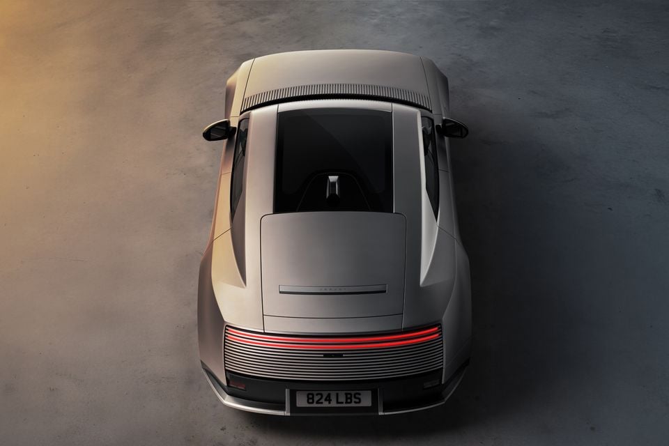 A silver Jaguar Type 00 concept car seen from above, showing its roof and rear end with illuminated red taillights