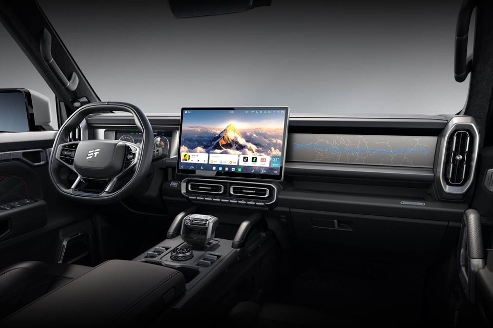 Dashboard of the Jetour T2 with a large floating touchscreen, chunky steering wheel, grab handles and a crystal-style gear selector on the centre console