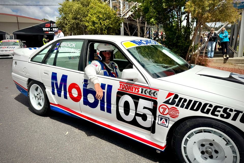 Kenny Habul seated in a white Mobil-liveried Holden VN Commodore SS Group A race car, number 05, in the pits at Bathurst