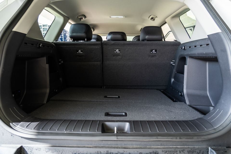 The open boot of a Kia EV5 SUV showing a large, empty cargo area with top-tether anchor points visible on the rear seatbacks.