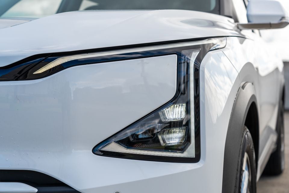 Close-up of the LED headlight on a white Kia EV5 SUV