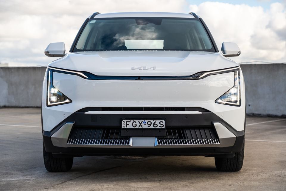 A white Kia EV5 SUV seen from the front, parked on a rooftop car park in Australia