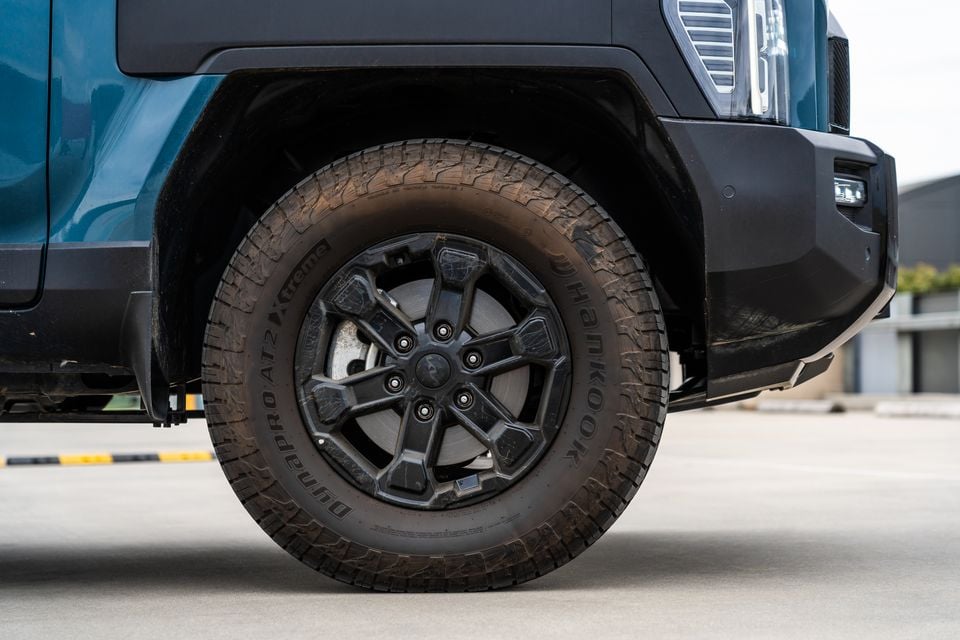Close-up of a black alloy wheel with Hankook Dynapro AT2 Xtreme all-terrain tyre on a teal Kia Tasman X-Pro ute