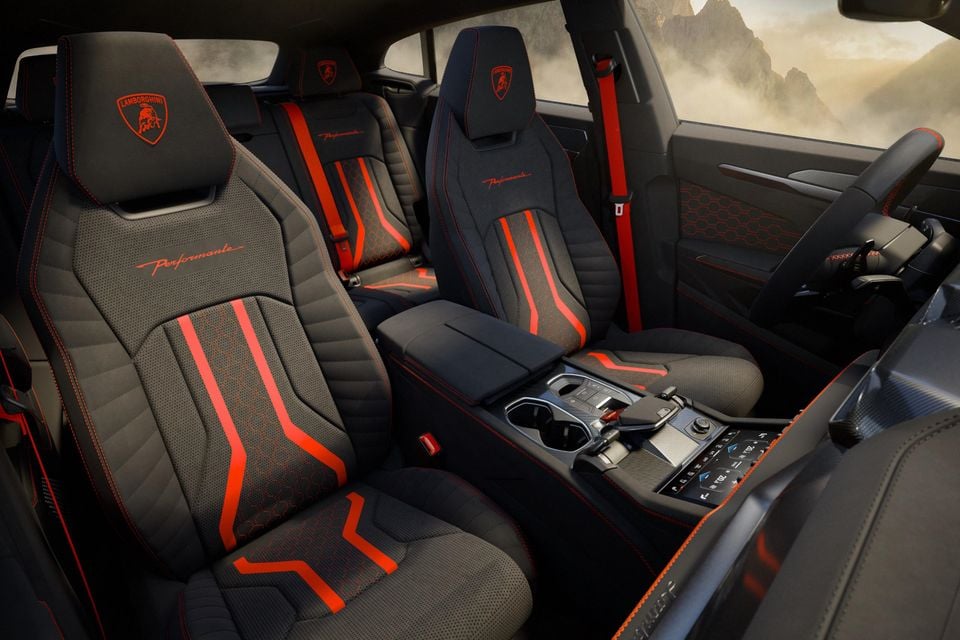 Lamborghini Urus SE Performante interior showing sport seats with bold red and orange striping, Lamborghini branding on headrests, centre console, and steering wheel