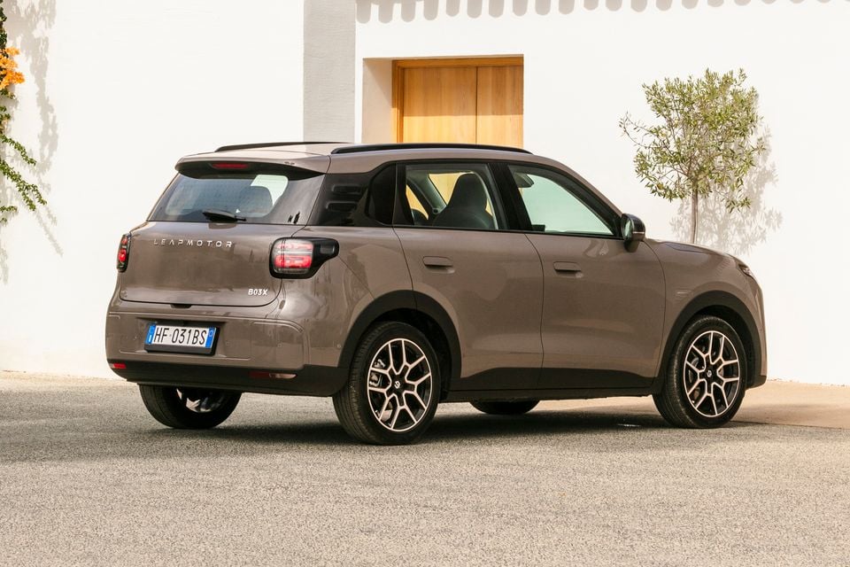 A brown Leapmotor B03X small SUV parked in front of a white wall, seen from the rear and side