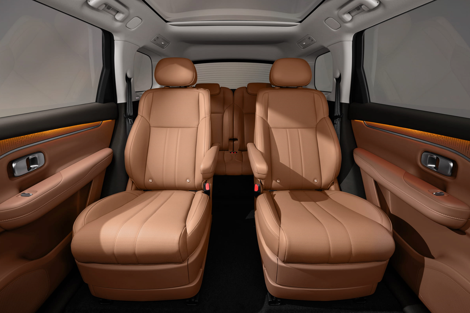 Tan leather second-row captain's chairs and third-row bench seat inside the Leapmotor C16 SUV cabin, with ambient-lit door trims