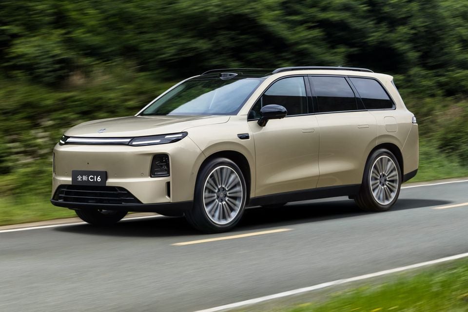 A champagne-coloured Leapmotor C16 SUV driving on a country road, seen from the front three-quarter angle