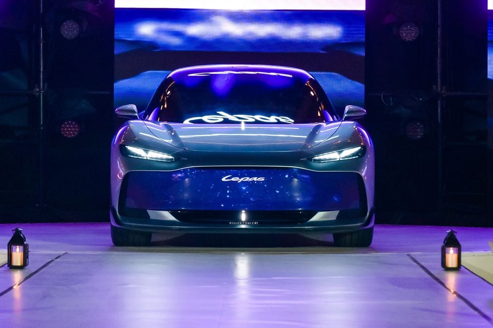 The Lepas Vision Concept car seen from the front on a stage, lit in purple and blue light with lanterns either side