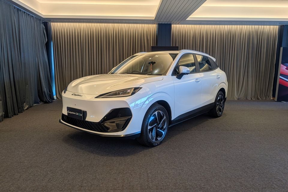 A white Lepas L4 EV electric SUV displayed indoors, seen from the front-side angle