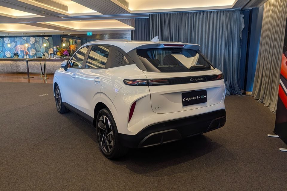 A white Cepas L4 EV SUV seen from the rear three-quarter angle at an indoor launch event
