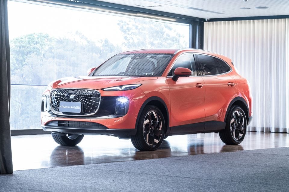 An orange Lepas L6 LSH SUV displayed indoors, seen from the front-left angle
