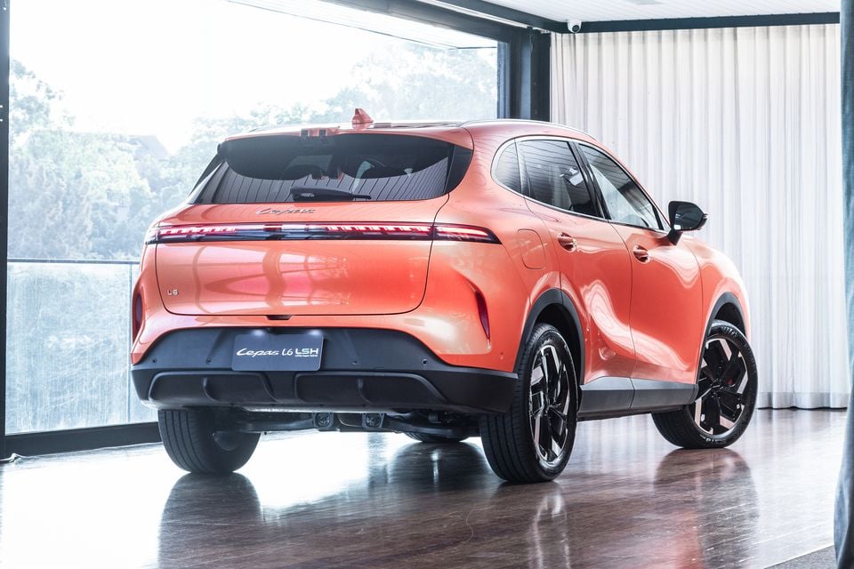 An orange Lepas L6 LSH SUV seen from the rear three-quarter angle inside a showroom
