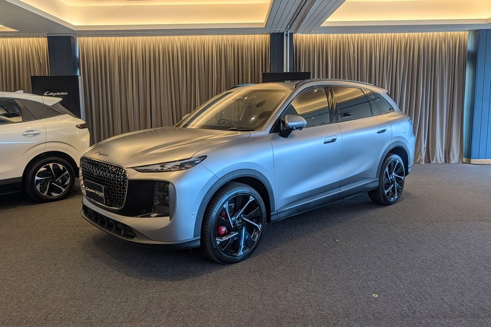 A silver Lepas L8 SUV displayed indoors at a showroom, seen from the front-left side