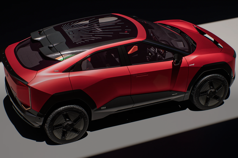 A red Mahindra BE 6 electric SUV concept seen from a high rear three-quarter angle, showing its swooping roofline, panoramic glass roof with decorative patterns, and sculpted body