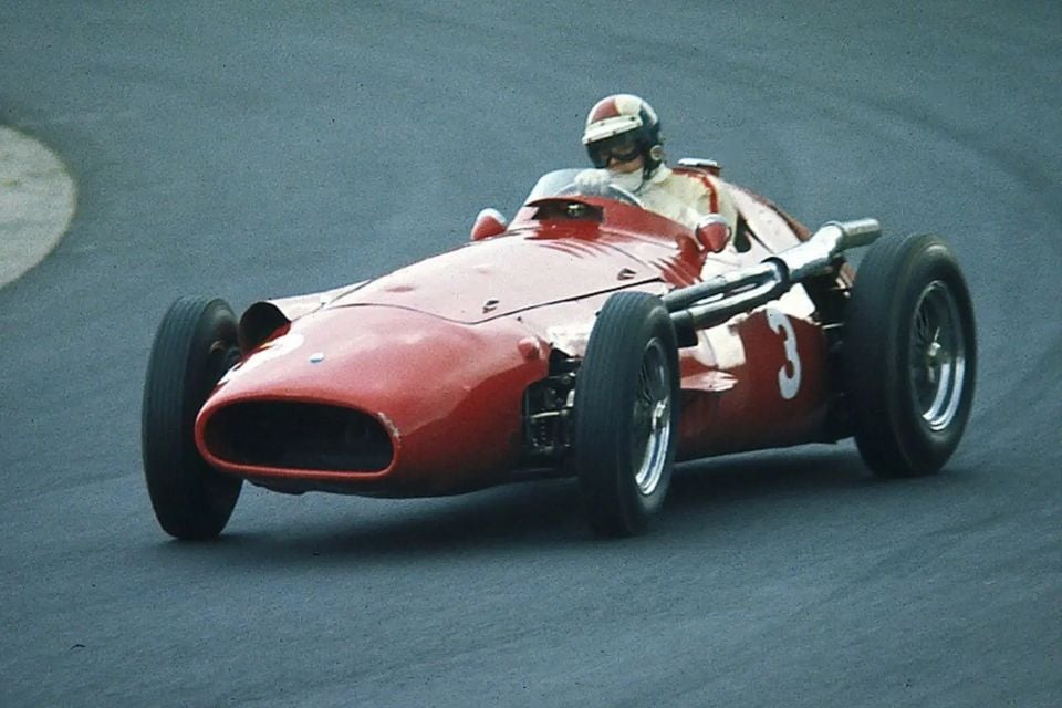 A red Maserati 250F classic open-wheel racing car, number 3, being driven through a corner on a race track