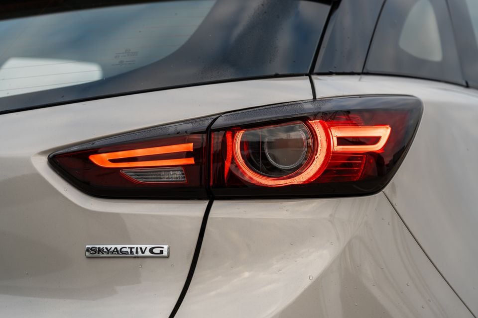 Close-up of the rear tail light on a white Mazda CX-3 with SKYACTIV-G badge visible