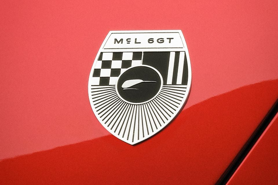 McLaren MCL6GT shield badge on a red car body panel