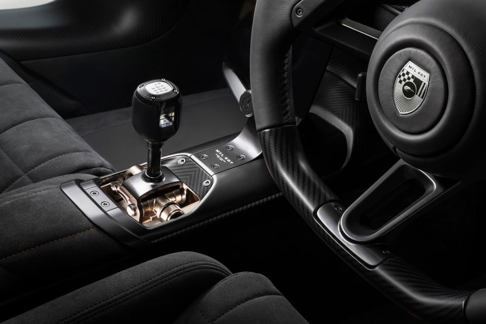 McLaren MCL6GT interior showing the manual gear shifter, carbon fibre centre console, and steering wheel with MCL6GT badge
