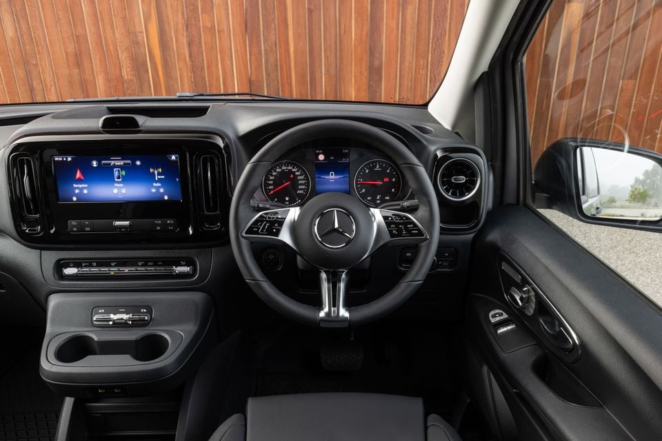 Interior of a Mercedes-Benz Vito showing the dashboard, steering wheel with three-pointed star logo, infotainment touchscreen, and instrument cluster from the driver's perspective in a right-hand-drive layout