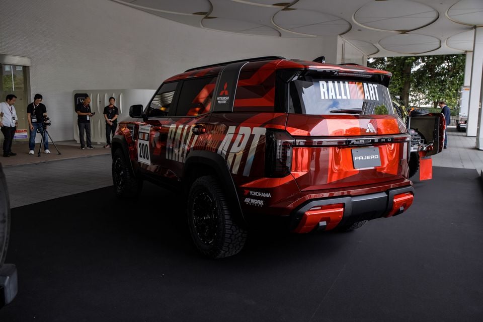 Rear three-quarter view of a red Mitsubishi Pajero SUV with Ralliart livery and race number 200, displayed at an indoor event