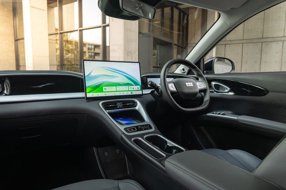 Interior of a Geely EX2 showing the large landscape-oriented touchscreen infotainment display, steering wheel, centre console and front seats