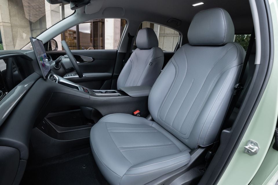Grey leather front seats of a Geely EX2 interior, with the dashboard, large touchscreen and centre console visible in the background