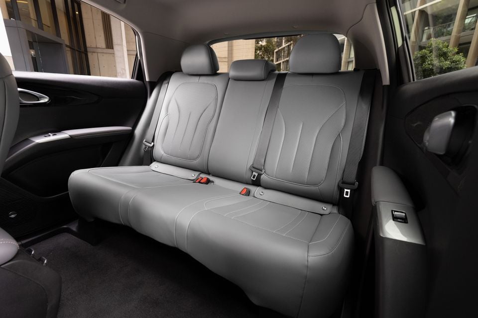 Rear interior of a Geely EX2 showing grey leather rear bench seat with seatbelts and individual headrests