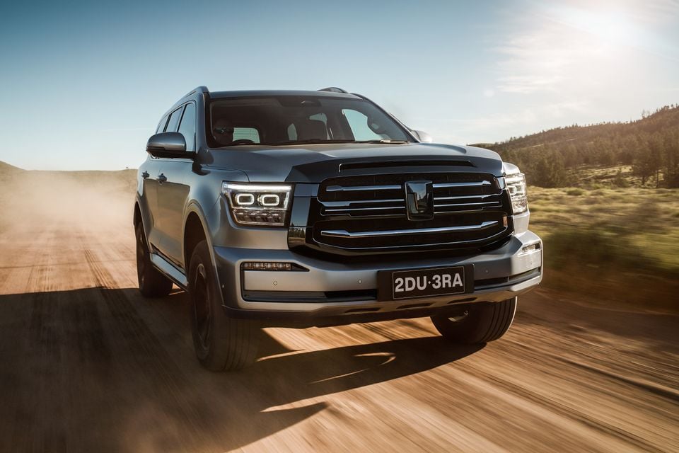 A grey GWM Tank 500 large SUV driving on a dirt road, seen from the front
