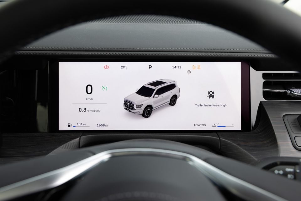 The digital instrument cluster of a GWM Tank 500 showing towing mode, trailer brake force settings, speed, RPM and vehicle graphic on screen.
