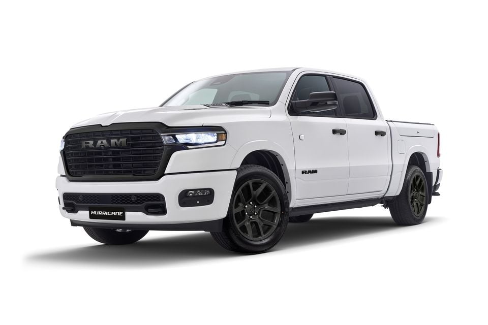 A white Ram 1500 Laramie Night Edition ute seen from the front-side, featuring a blacked-out grille, dark alloy wheels, and Hurricane badging on the front bumper, shown on a white background.