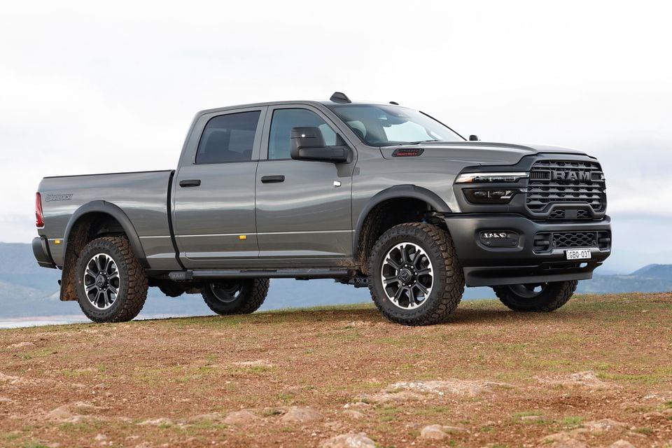 A grey RAM 2500 Warlock Heavy Duty ute parked on a hilltop, seen from the front-side angle with off-road tyres and black alloy wheels