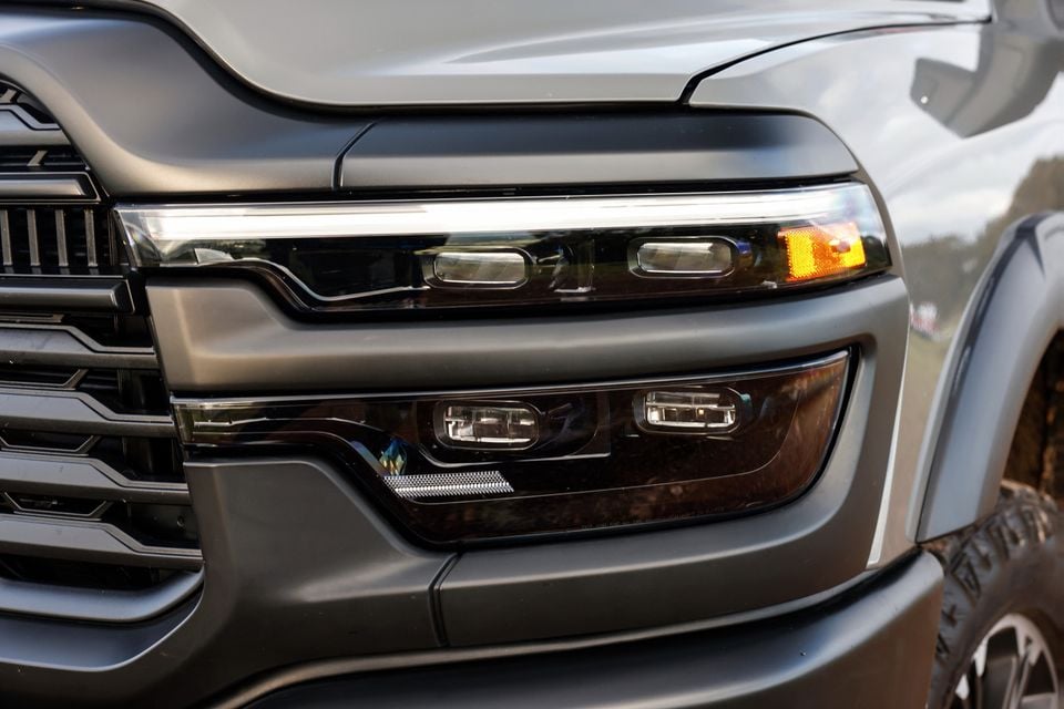 Close-up of the headlight and grille on a grey 2026 Ram 2500 Warlock pickup truck