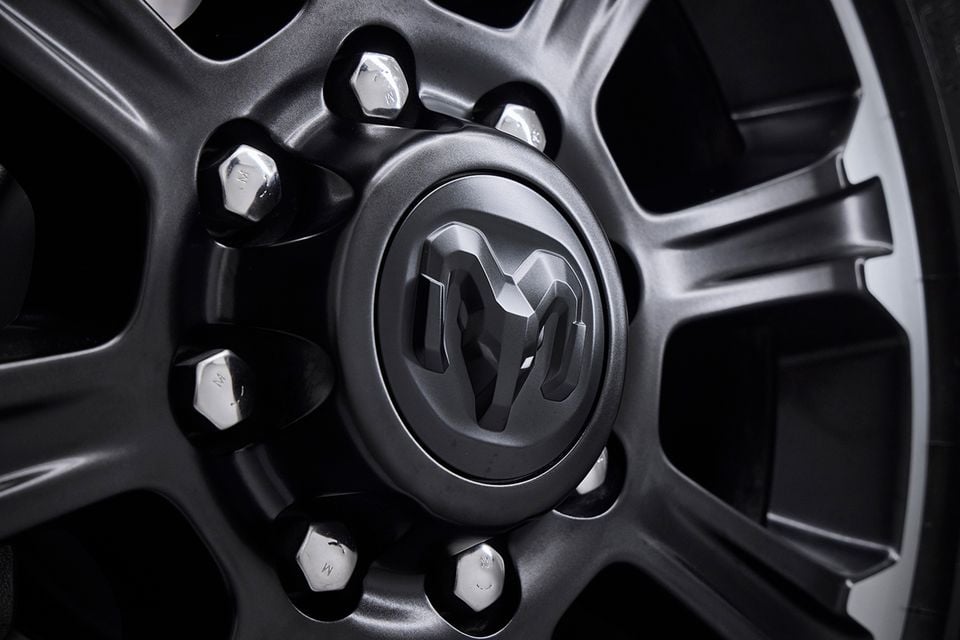 Close-up of a dark grey alloy wheel with the Ram badge on the centre cap of a Ram 2500 Warlock truck
