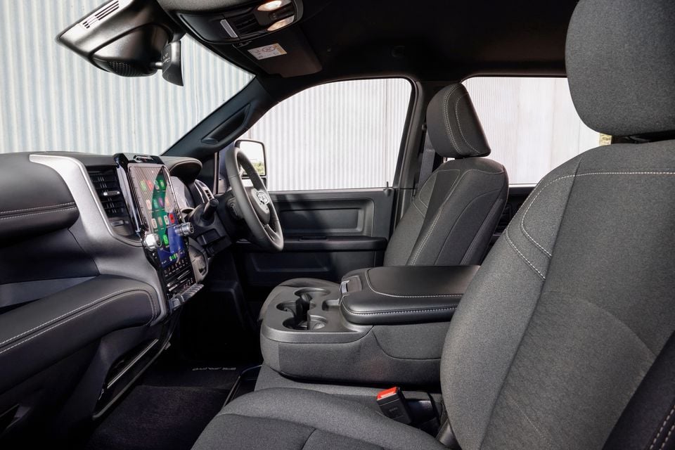 The interior of a Ram 2500 Warlock pickup truck showing the front seats, steering wheel and centre console with cupholders