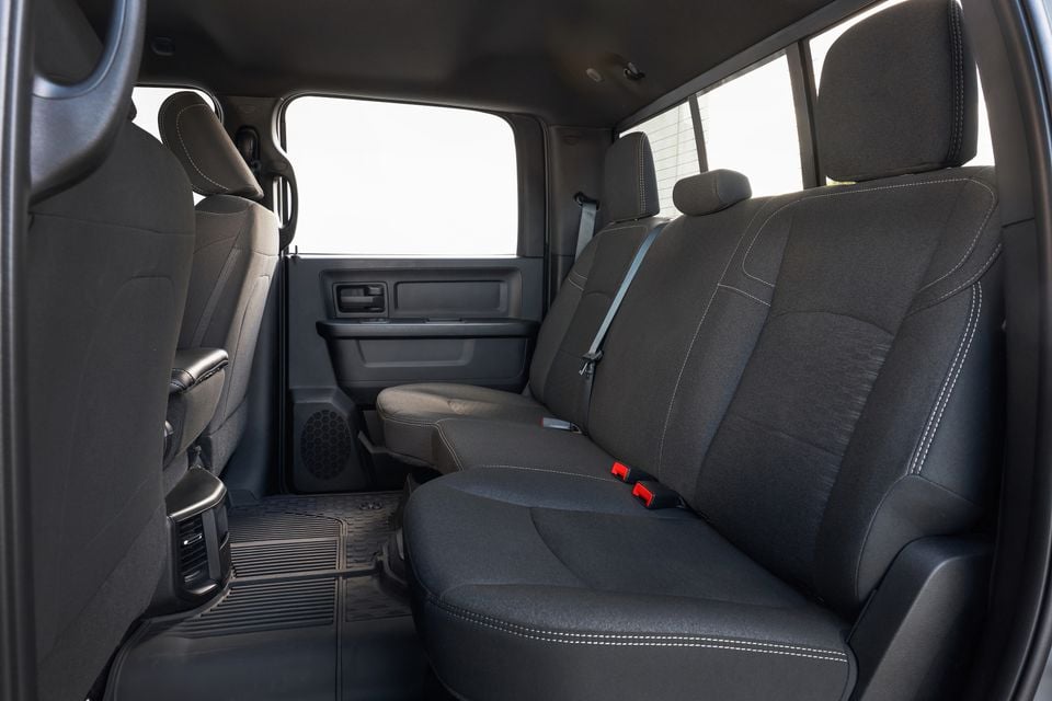 The rear bench seat of a 2026 Ram 2500 Warlock crew cab, shown with black cloth upholstery and door panel