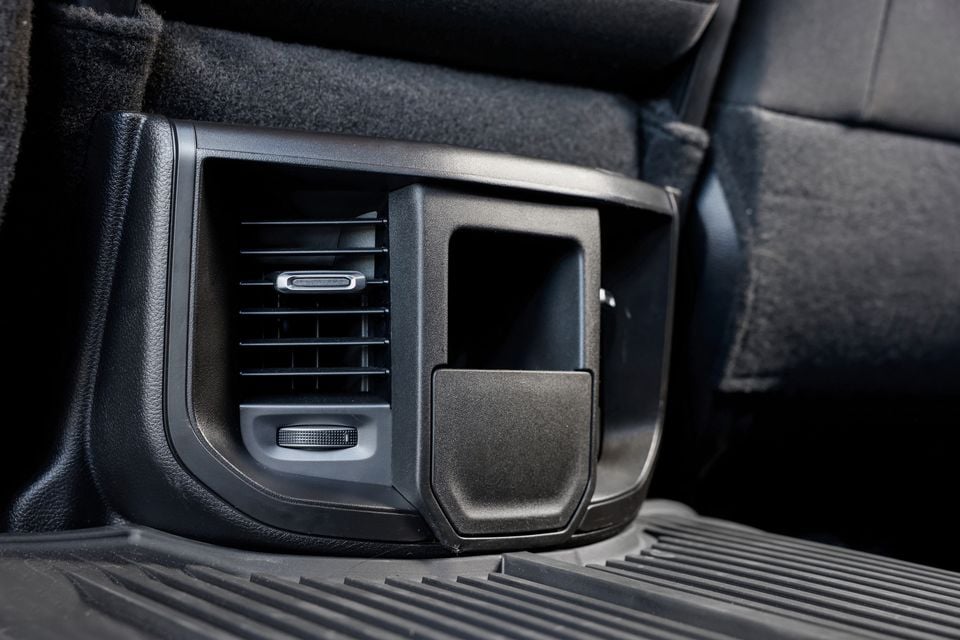 Close-up of the rear centre console air vents and storage compartment inside a Ram 2500 Warlock's cabin