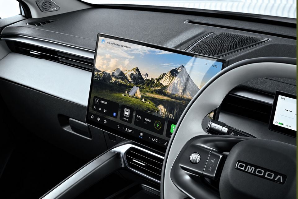 Interior of a Chery OMODA E5 showing the large central touchscreen infotainment display and steering wheel, viewed from the driver's side