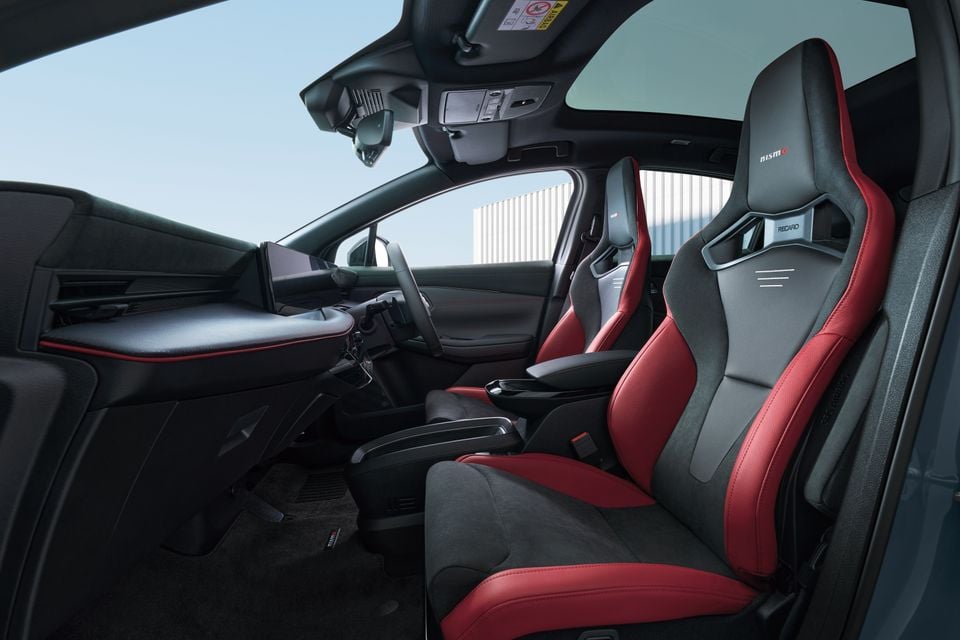 Interior of a Nissan Leaf Nismo showing red and black Recaro sports seats, centre console, and dashboard with a right-hand drive layout