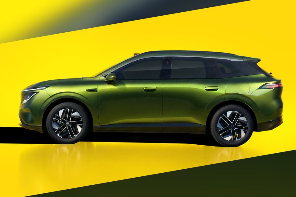 A green Nissan NX7 SUV wagon seen from the side against a yellow and dark background
