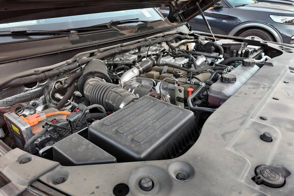 Engine bay of a Nissan Terrano with the bonnet open, showing the turbocharged engine, intake piping, and ancillaries