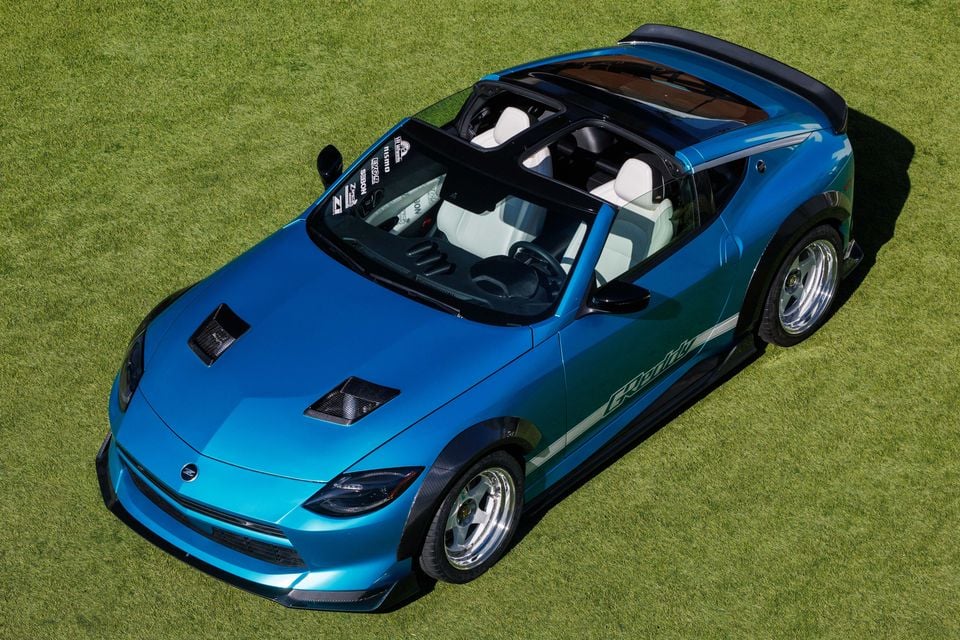 A blue Nissan Z Kaze concept convertible with its roof removed, shown from an elevated angle parked on grass