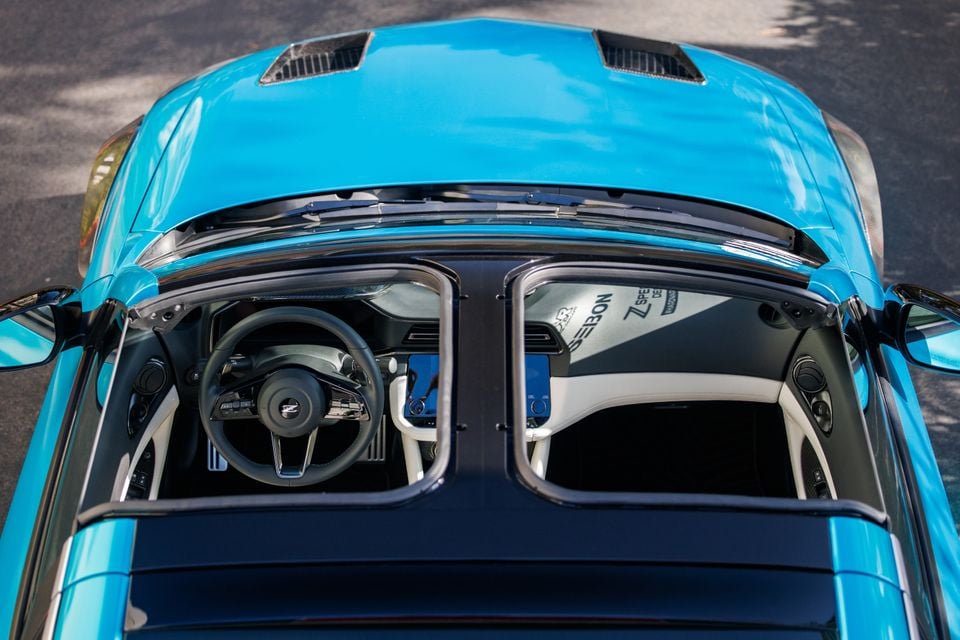 A blue Nissan Z Kaze concept car seen from above, showing its roofless cabin with steering wheel and dashboard