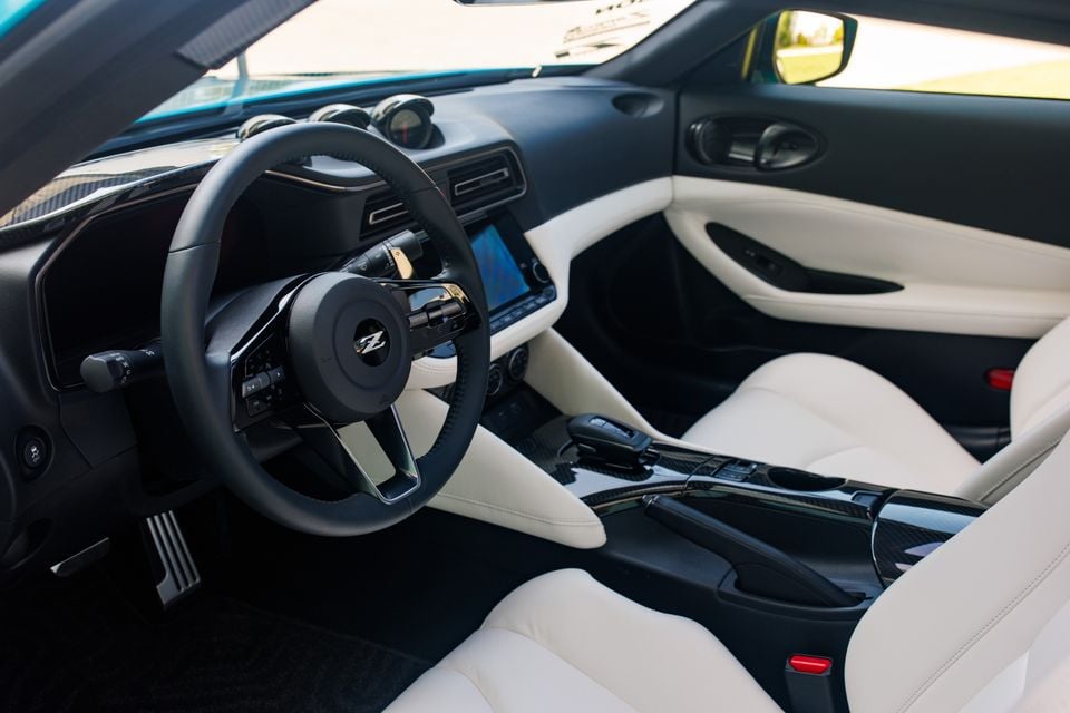 The white and black interior of a Nissan Z Kaze concept, showing the steering wheel, dashboard and centre console