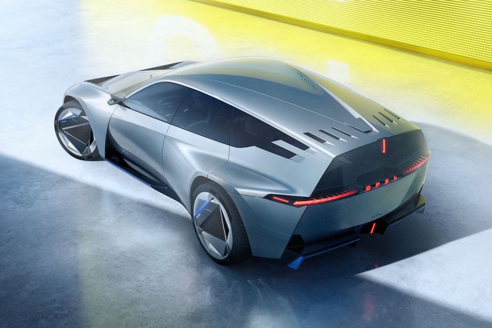 Conceito Opel STX prateado visto de um ângulo traseiro elevado, mostrando o tejadilho, perfil lateral e barra de luz vermelha com inscrição Opel