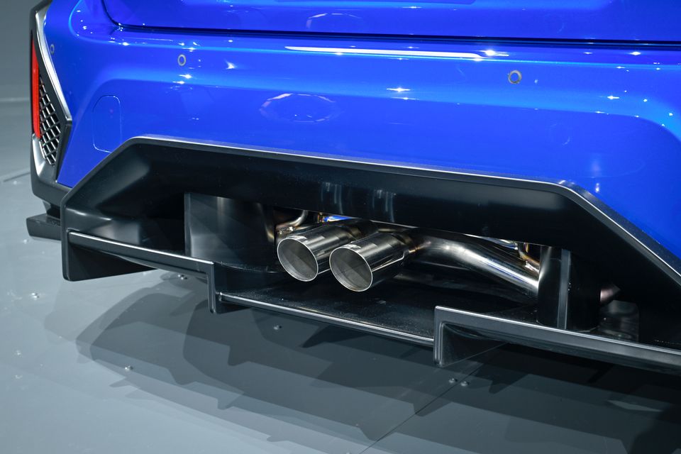 Close-up of the twin exhaust tips and rear diffuser on a blue Subaru STI concept car