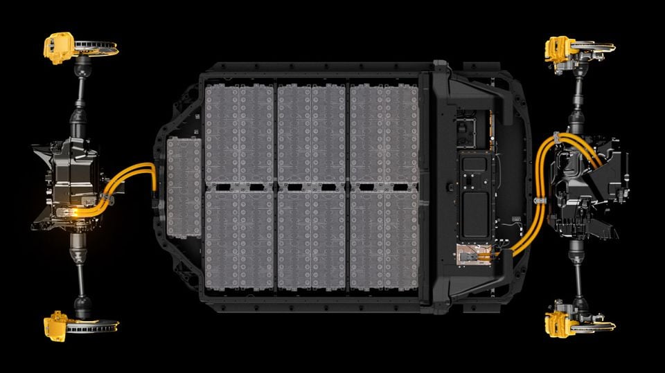 Overhead cutaway render of the Polestar 3's battery pack and dual electric motor platform, with orange high-voltage cables and yellow brake callipers