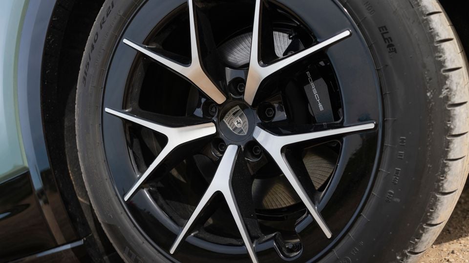 Close-up of a Porsche Cayenne Turbo E-Hybrid alloy wheel with a black and machined-face finish and Porsche-branded brake caliper
